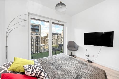 罗兹Luxury in City -2-Bright-Secure&FreeParking的一间卧室配有一张床和一台平面电视