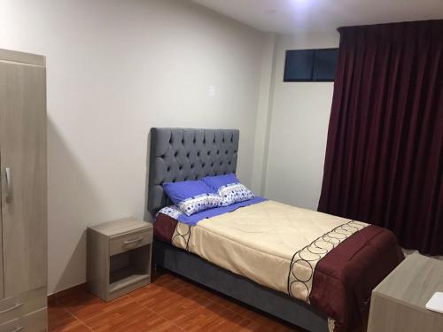 利马100- departamento céntrico en chorrillos的小卧室配有一张蓝色床头板的床