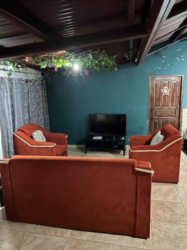 塞罗蓬塔Bambito´s Café & Hostel的客厅配有两把椅子和电视
