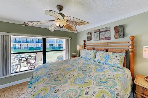 圣奥古斯丁Sea Fair Condo Unit 12128的一间卧室配有一张带吊扇和窗户的床。