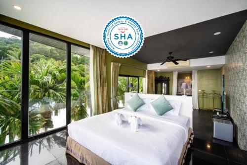 芭东海滩See Sea Villa Phuket SHA的卧室设有一张大白色的床和大窗户