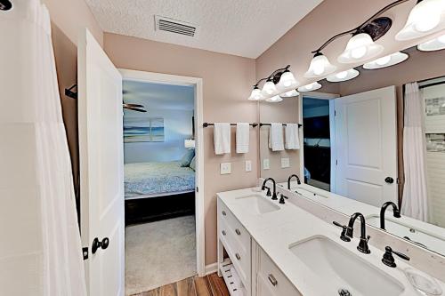 圣奥古斯丁Trade Wind Cabana的一间带两个盥洗盆和大镜子的浴室