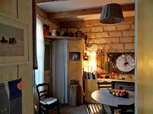 艾格-莫尔特Chambre d'hôte Farniente的厨房配有桌子和墙上的时钟