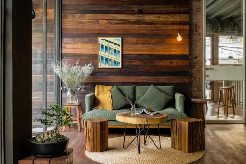 曼谷Tamni的客厅配有绿色沙发和桌子