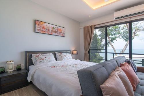 普吉镇Koh Sirey Beachfront Pool Villa的一间卧室设有一张床和一个大窗户