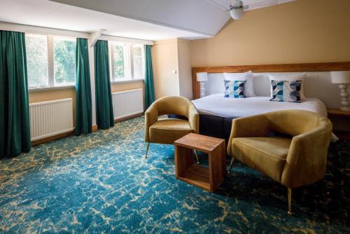 霍尔滕胡格霍尔顿餐厅酒店的酒店客房,配有一张床和两把椅子