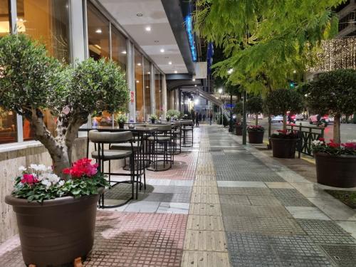 比雷埃夫斯萨沃伊酒店的一条有桌椅和盆栽的街道
