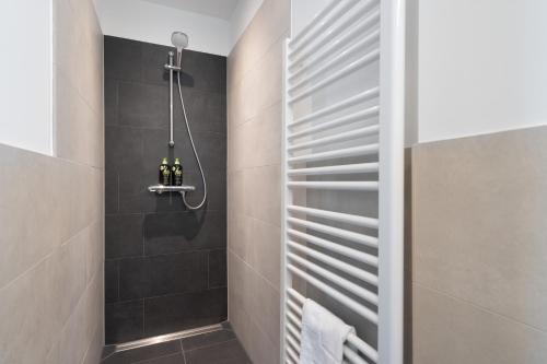 波茨坦limehome Potsdam Annemarie-Wolff-Platz的浴室设有黑色瓷砖淋浴。