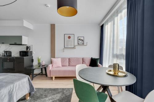 格但斯克RentPlanet - Apartamenty Chlebova的客厅配有粉红色的沙发和桌子