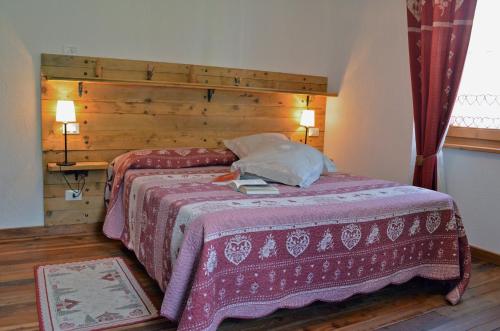 奥斯塔La Maison De José的一间卧室配有一张大床和木制床头板