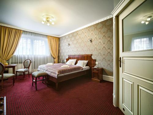 比亚韦斯托克ApartHotel Hubertus的卧室配有一张床和一张桌子及椅子