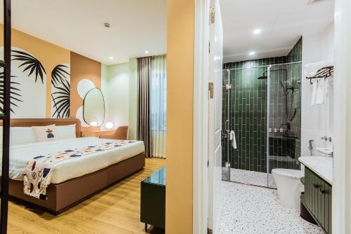 下龙湾Palette Collect's Boutique Hotel Ha Long的一间卧室配有一张床和淋浴,还有一间浴室