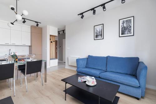 克拉科夫Lotniczówka Apartments by Renters Prestige的客厅配有蓝色的沙发和桌子
