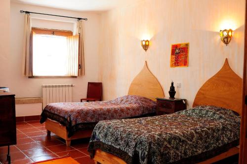 里奥马约尔Casa d'Aldeia的酒店客房设有两张床和窗户。