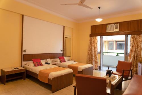 孟买大海绿色酒店 的酒店客房,设有两张床和一张沙发