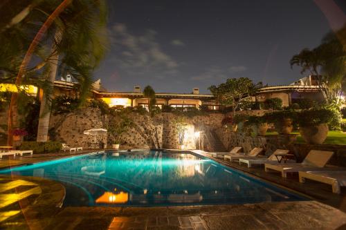 库埃纳瓦卡卡拉斯马纳尼塔斯酒店的一座游泳池,在晚上在建筑物前