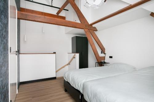 栋堡Hello Zeeland - Appartement Weststraat 36的卧室设有白色的床和木梁。