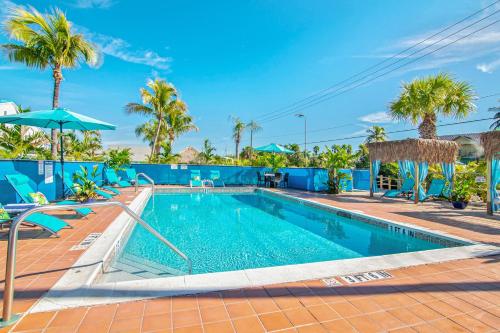迈尔斯堡海滩Latitude 26 Waterfront Resort and Marina的棕榈树度假村内的游泳池