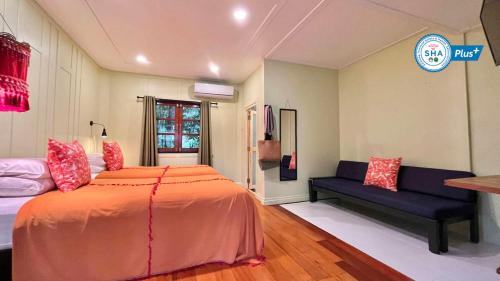 库德岛Baan Bua Cottage SHA EXTRA PLUS B5510的一间卧室配有一张大床和一张沙发
