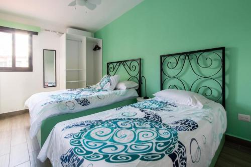 坎昆Casa Korima Cancun - Luxurious - Budget Friendly的绿墙客房内的两张床