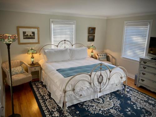 麦迪逊The Homestead的卧室配有白色的床和椅子