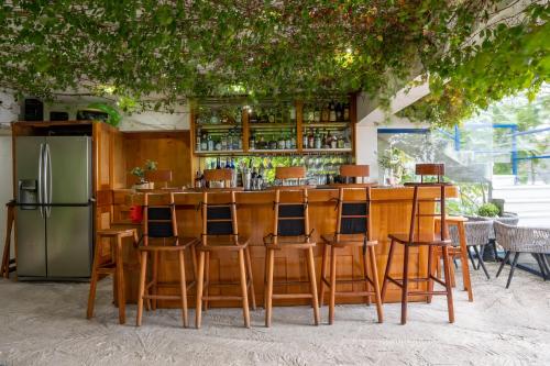 圣马科斯拉拉古纳El Dragon Hotel的酒吧配有木椅和冰箱