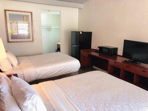 圣何塞Extended Studio Suites的酒店客房设有两张床和电视。