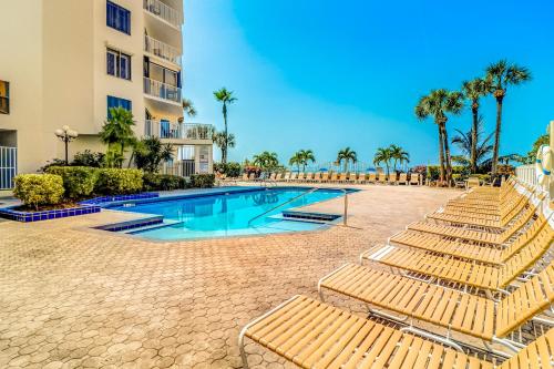 克利尔沃特Beach Palms的一个带躺椅的游泳池,棕榈树