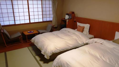 登别滝乃家别馆玉乃汤的酒店客房设有两张床和窗户。
