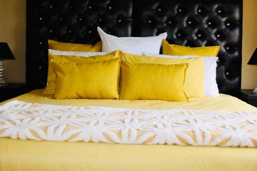 咖啡湾Coffee Bay Lodge的一张带黄色枕头和黑色床头板的床