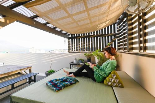鹿儿岛绿色宾馆 的坐在阳台上长凳上的女人