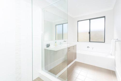 珀斯The Kingsley’s Place - EXECUTIVE ESCAPES的带淋浴和盥洗盆的白色浴室