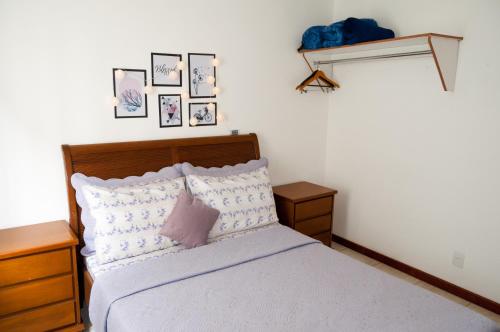 彼得罗波利斯Apartamento aconchegante的一间卧室配有一张床,墙上挂着一些图片