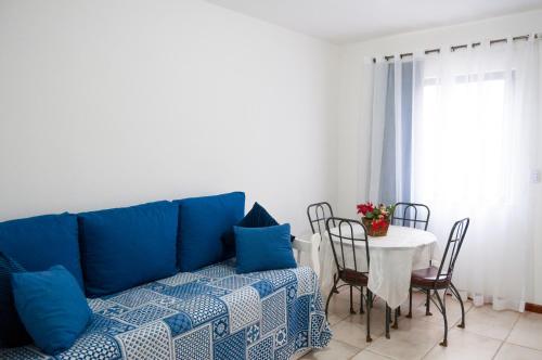 彼得罗波利斯Apartamento aconchegante的客厅配有蓝色的沙发和桌子