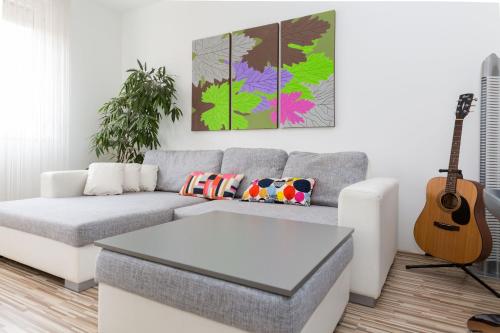 布达佩斯Mentha Apartments Deluxe - MAD的带沙发和吉他的客厅
