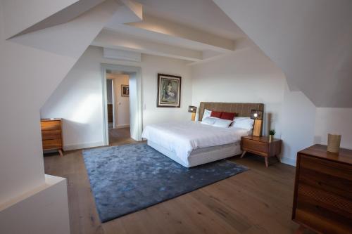 布达佩斯ZOYA LUXURY RESIDENCE的卧室配有白色的床和蓝色地毯。