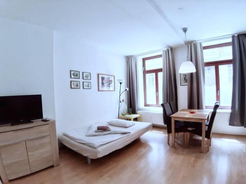 莱比锡Studio Zentrum Süd的客厅配有床、桌子和电视