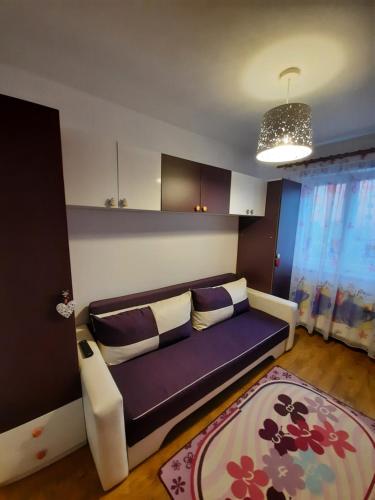 锡比乌Happy apartament的客厅配有紫色沙发和地毯。
