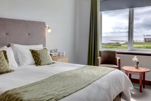 BlackwaterfootKinloch Hotel, Isle of Arran的一间卧室设有一张大床和一个大窗户