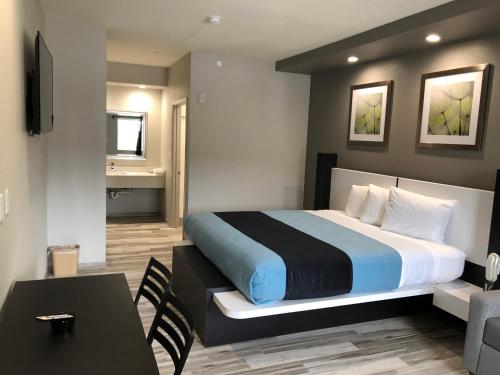 休斯顿Crystal Inn Downtown的配有一张床、一张桌子和一张桌子的酒店客房