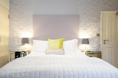 布里斯托熊与天鹅宾馆的卧室配有一张白色大床和黄色枕头