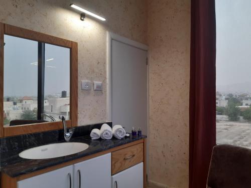 杰里科Dolphin Suites Hotel的一间带水槽和镜子的浴室以及窗户。