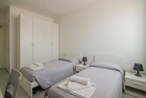 帕多瓦Casa Lucia Valentini Terrani的配有两张床铺的客房配有两盏灯和一把椅子
