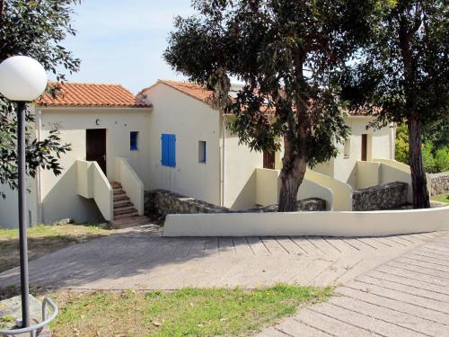 阿尔加约拉Apartment Cala di Sole - ALG131 by Interhome的前面有一棵树的房子