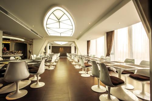 广州广州普兰内特概念酒店的一间带桌椅的用餐室和窗户。