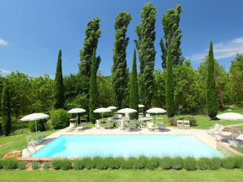 拉波拉诺泰尔梅Apartment Aia by Interhome的花园内带桌子和遮阳伞的游泳池