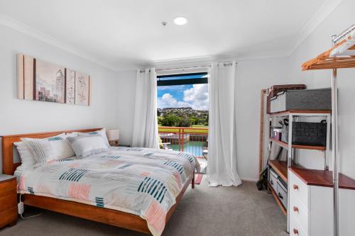 Te WhangaHarbourside Haven - Whangaparāoa Studio Apartment的一间卧室设有一张床和一个窗口