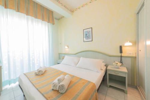 卡托利卡Hotel Cavalli的一间卧室配有带毛巾的床