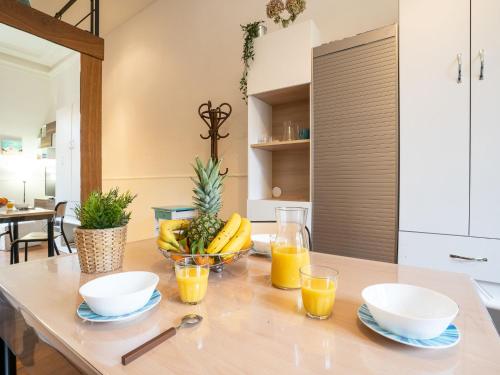 比亚里茨Apartment Carlton-1 by Interhome的桌子,放着一碗水果和橙汁