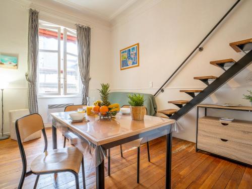 比亚里茨Apartment Carlton-1 by Interhome的客厅设有餐桌和楼梯。
